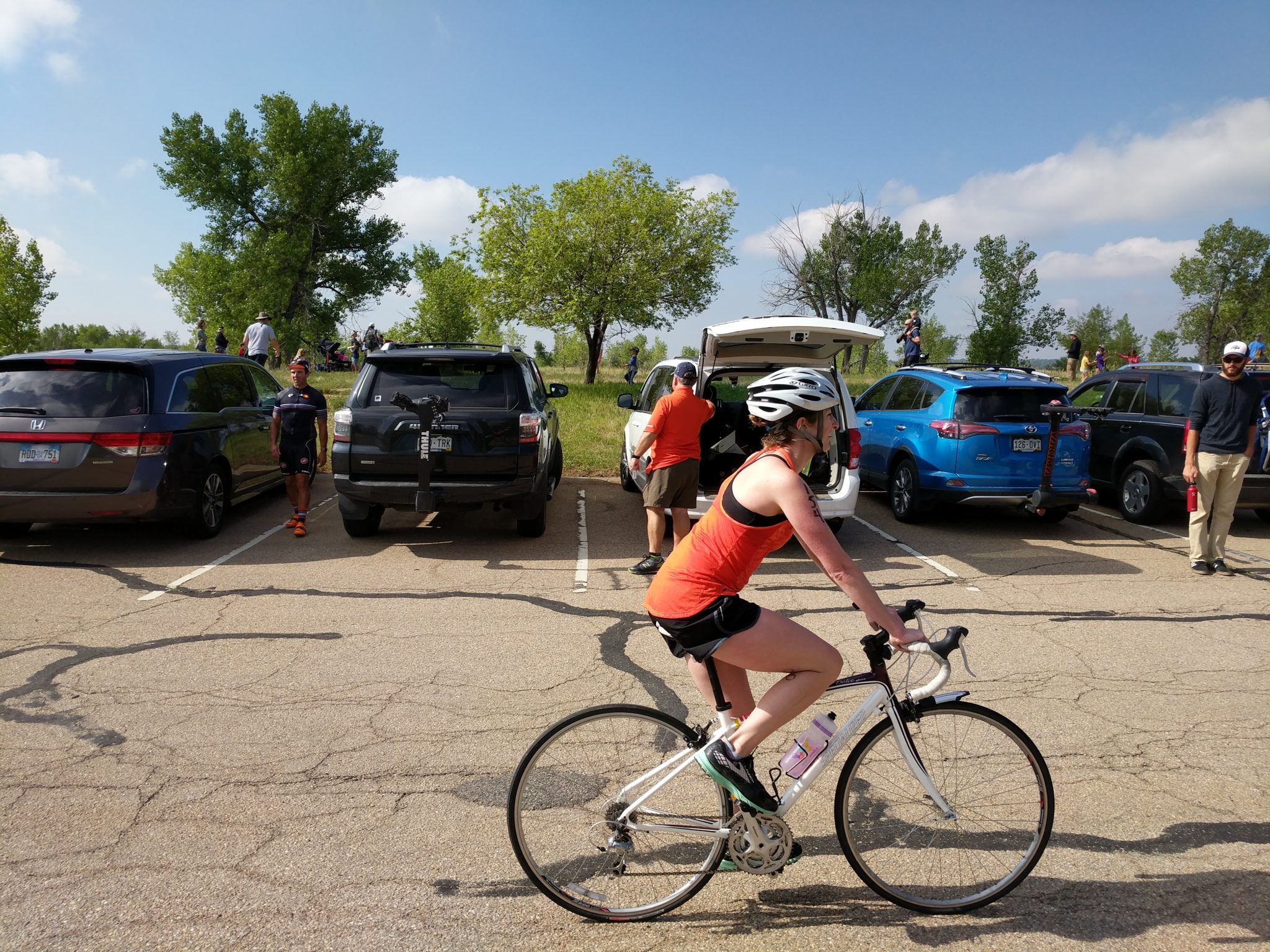 A person riding a road bike in a parking lot.