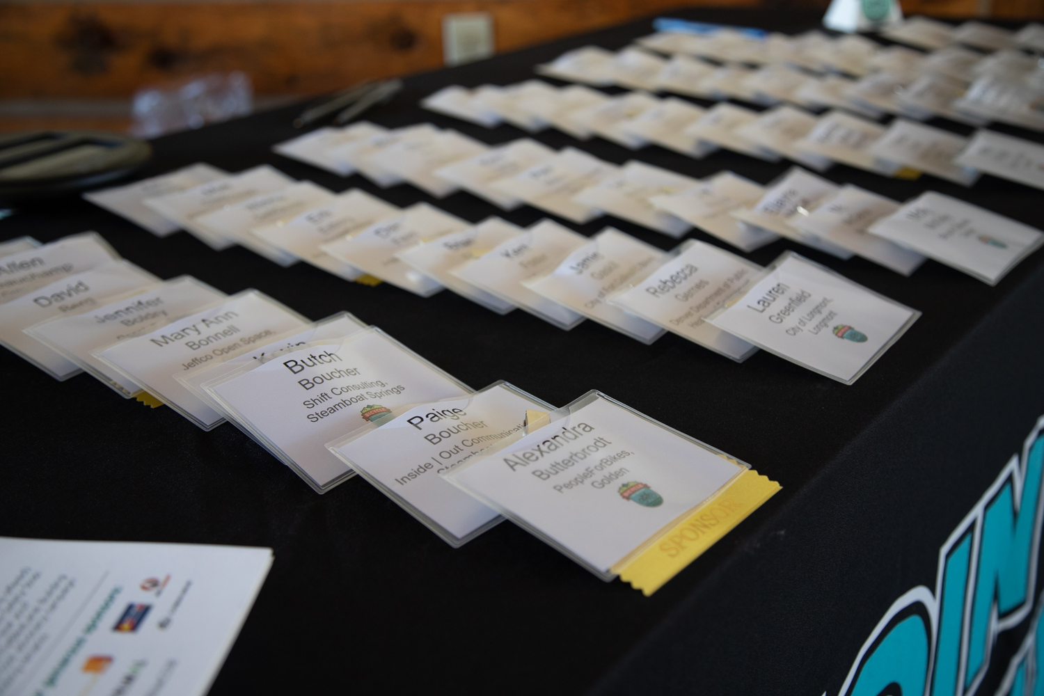 A close up of nametags on a table covered in a black tablecloth.