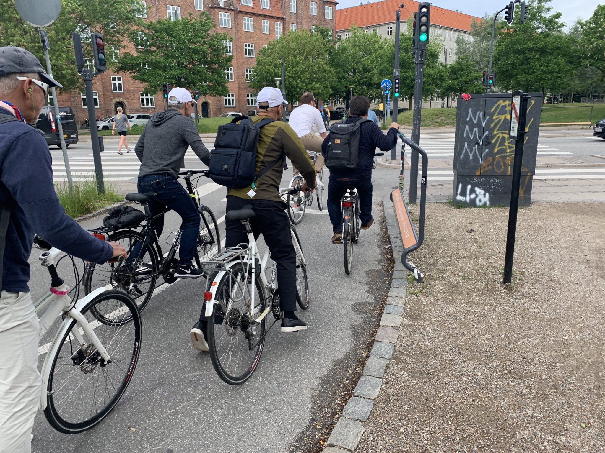 People crossing an intersection on a bike path.
