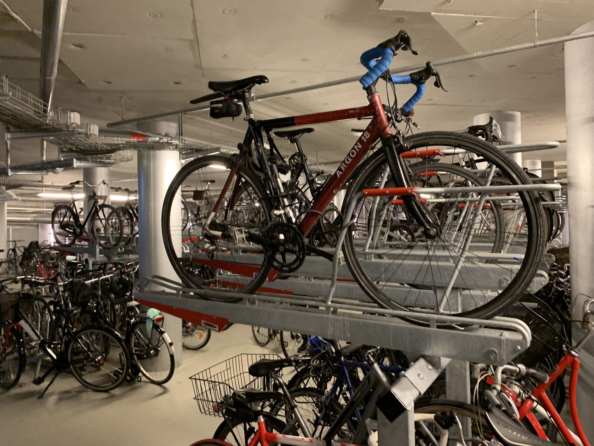 Bikes parked in racks in an underground bike parking garage.