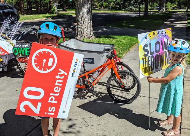 Kids with street calming signs