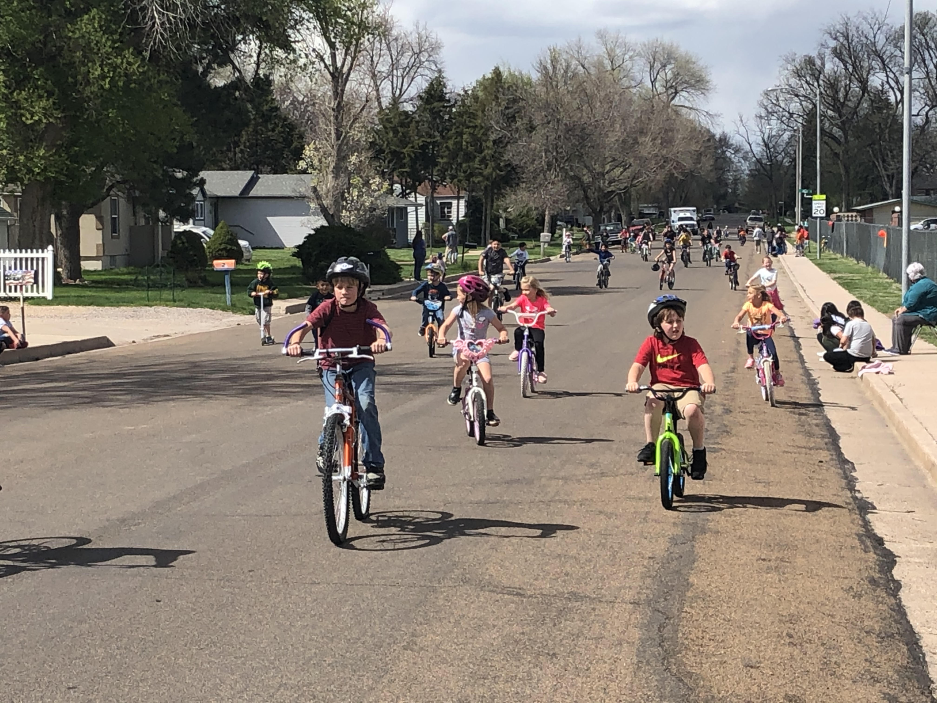 A group of children ride toward the camera on a street.