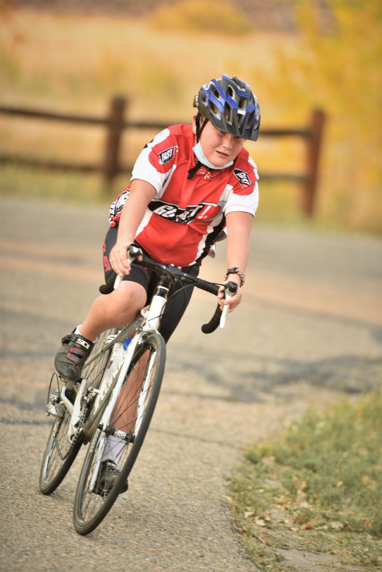 A child rides a road bike toward the camera.