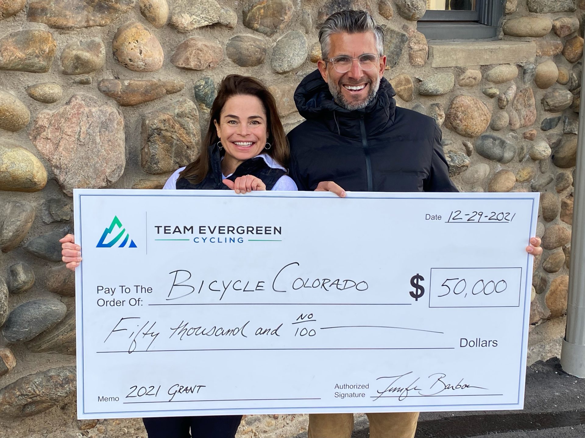 Team Evergreen Grant two people standing behind large check valued at 50000 dollars