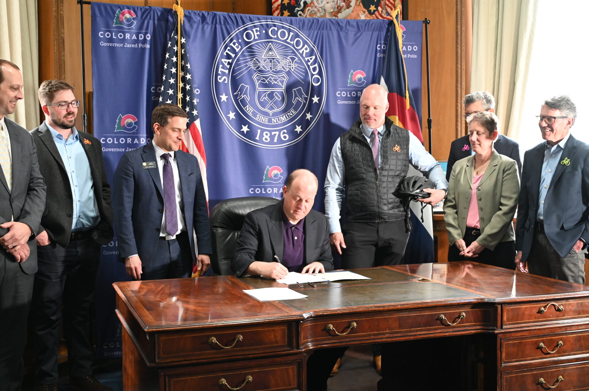 People watch as governor signs a bill