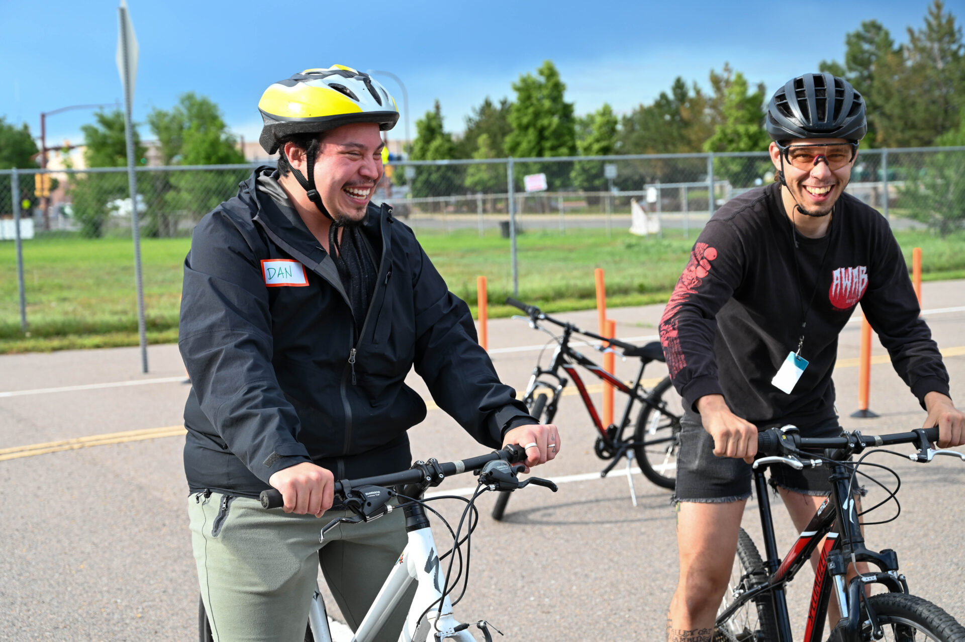 Two people on bikes smiling.