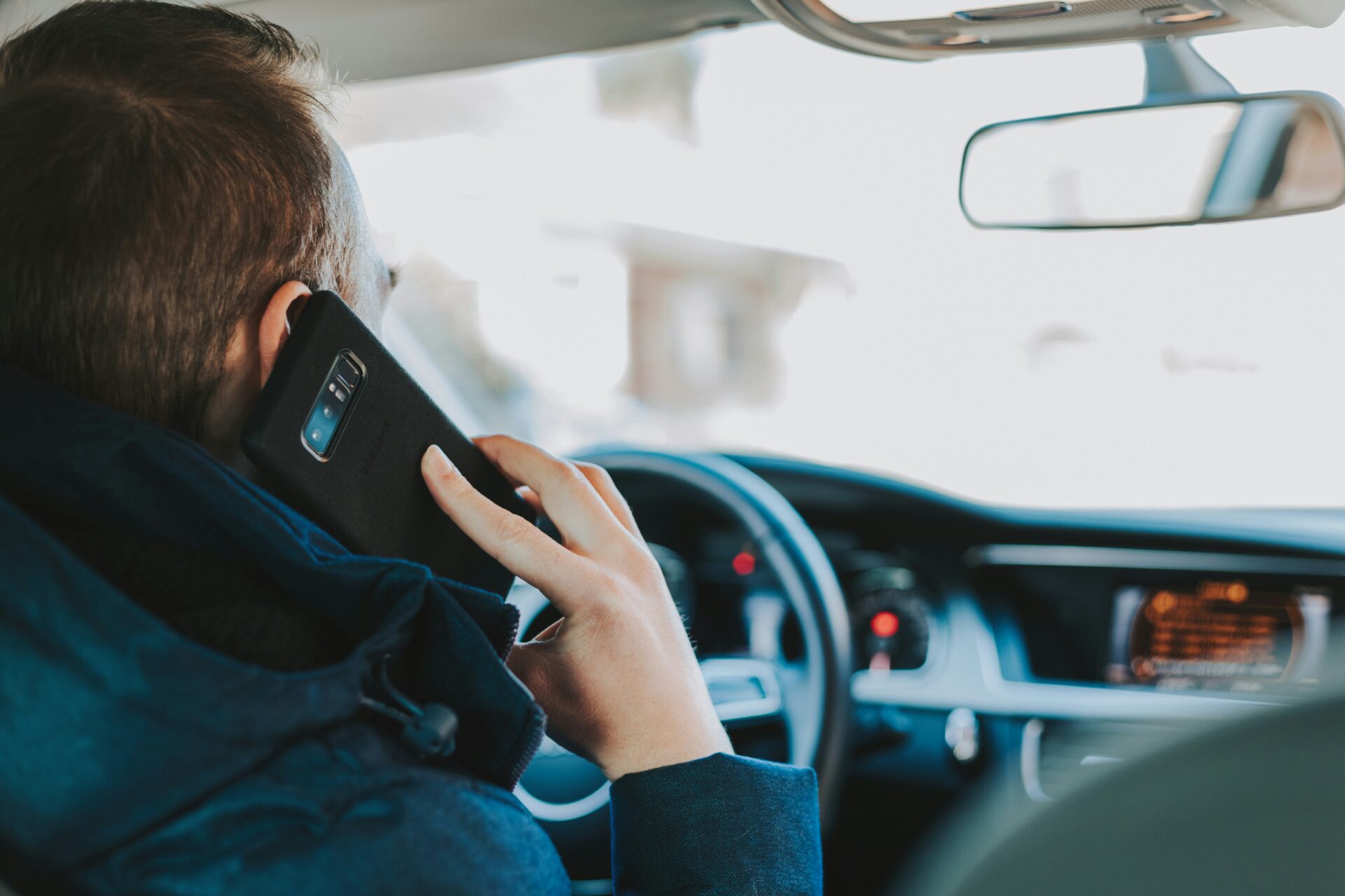 Man talking on cell phone in car